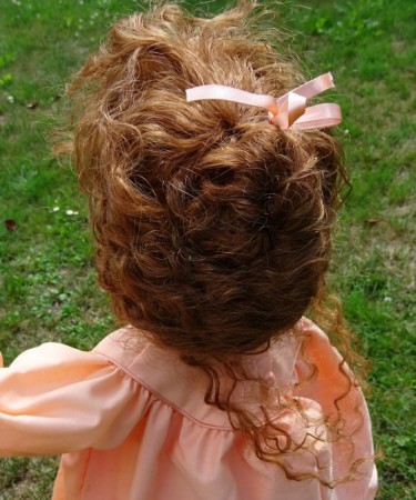 Bohatá vlasová paruka svázaná do uzlu